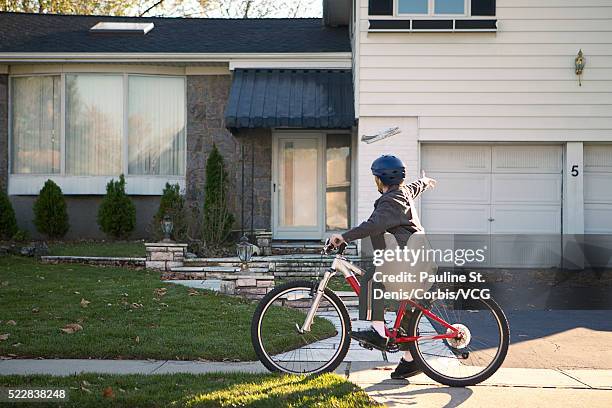 boy delivering newspapers on his bicycle - zeitungsausträger stock-fotos und bilder