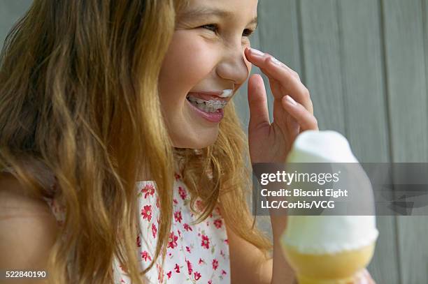 girl eating soft-serve ice cream cone - girl eating messy ice cream cone stock-fotos und bilder