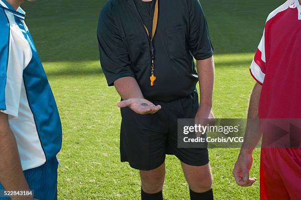 referee displaying the outcome of a coin toss, two soccer players look on - flipping a coin stock pictures, royalty-free photos & images