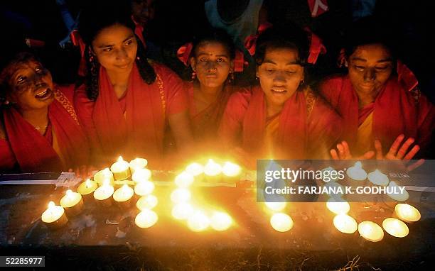 Bangladeshi acid attack victims use candles to write the word 'ACID' as they take part with others in a ceremony to mark International Women's Day in...