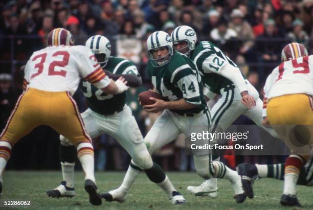 New York Jets' running back John Riggins gets the hand off from quarterback Joe Namath and runs with the ball against the Washington Redskins during...