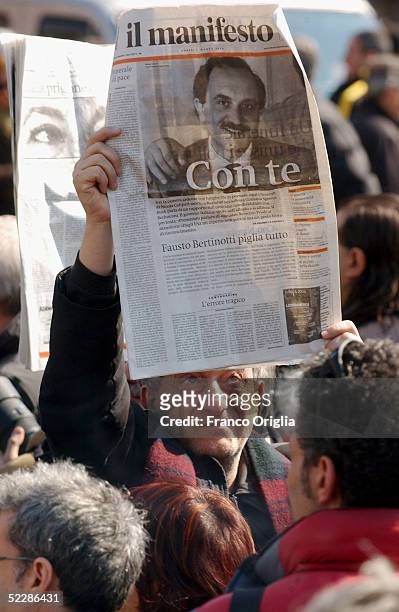 Man holds up the Italian journal Il Manifesto showing Italian intelligence officer Nicola Calipari on the front cover outside Santa Maria Degli...