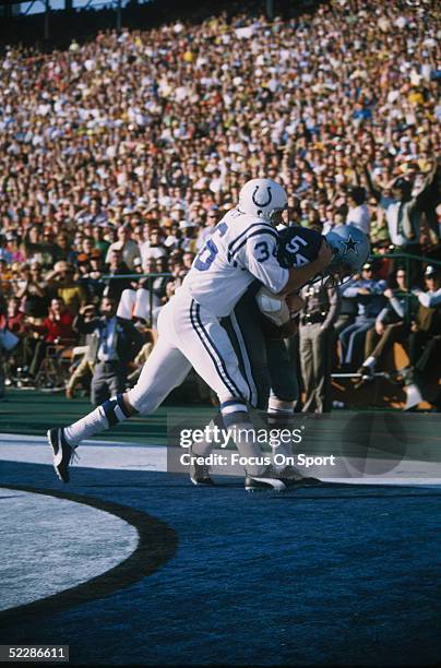 Dallas Cowboys' linebacker Chuck Howley holds on to the ball after making an interception as Norm Bulaich of the Baltimore Colts tackles him in the...