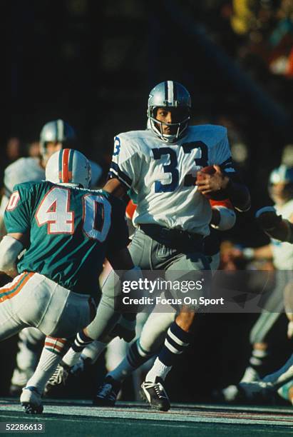 Running back Duane Thomas of the Dallas Cowboys runs with the ball as Dick Anderson of the Miami Dolphins tries to tackle him during Super Bowl VI at...