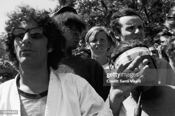 American political activist Abbott "Abbie" Hoffman gestures as he stands in the midst of a crowd of demonstators gathered in protest of the...