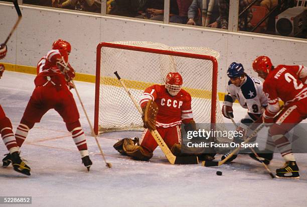 Goalie Vladimir Myshkin and Viacheslav Fetisov of the Soviet Union defend the net as Neal Broten of Team USA goes for the puck during the XIII...
