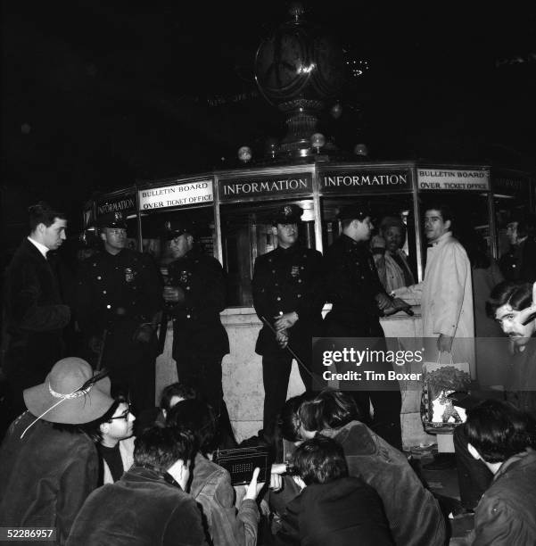 Police officers stand around the information booth in Grand Central Station as students and members of the Youth International Party, or Yippies,...