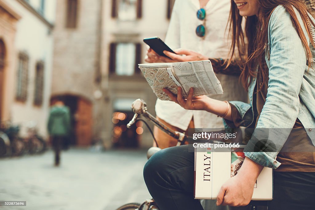 Tourists with guide and map in alleys of Italy