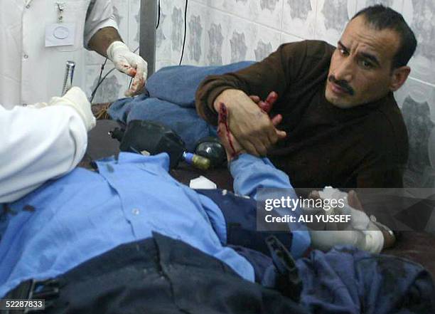 An Injured Iraqi policeman is comforted by a colleague in the main hospital in the northeastern city of Baquba, 60 kms from Baghdad 07 March 2005,...