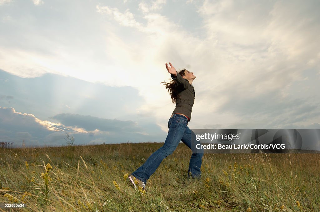 Teen girl dancing in a field