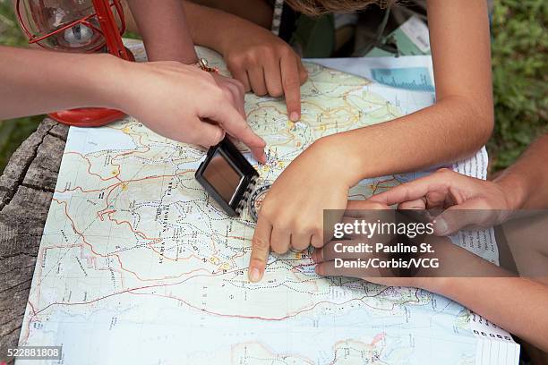 friends examining map - orientierungslauf landkarte gruppe stock-fotos und bilder