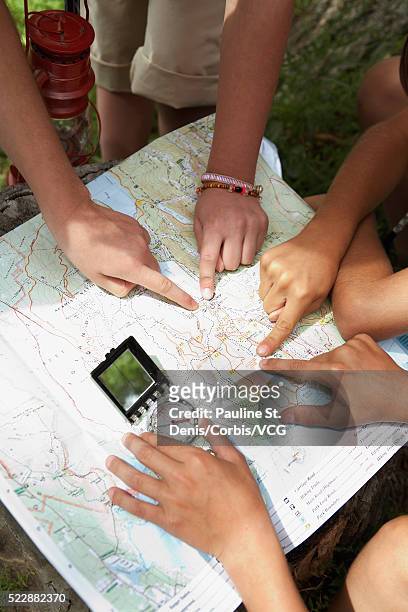 friends examining map - orientierungslauf landkarte gruppe stock-fotos und bilder
