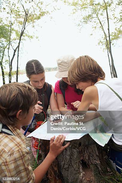 friends examining map - orientierungslauf landkarte gruppe stock-fotos und bilder