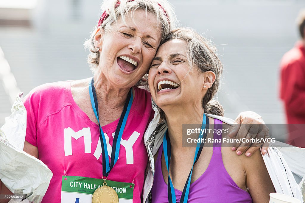 Women taking part in road race having medals and celebrating winning