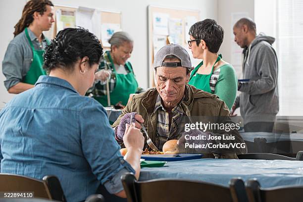 homeless people eating meal in soup kitchen - homeless shelter man stock pictures, royalty-free photos & images