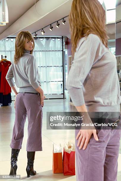 woman trying on clothes at store - woman-looking-into-mirror-full-body stock pictures, royalty-free photos & images