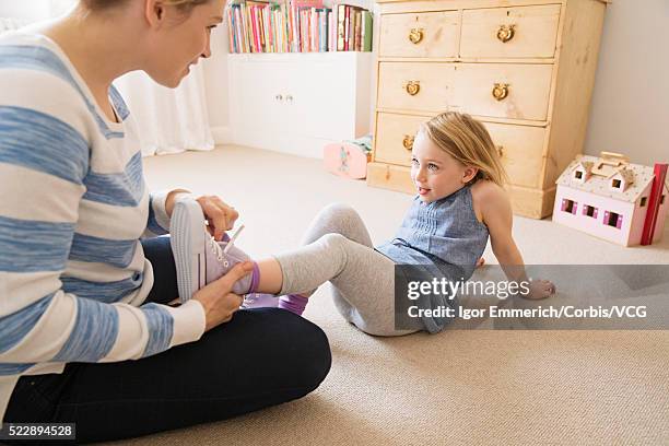 mother tying daughters (4-5) shoe - sporting footwear stock pictures, royalty-free photos & images