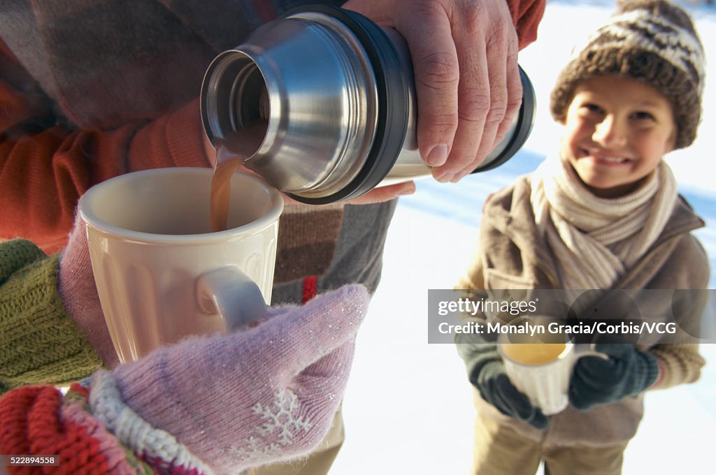 Pouring hot chocolate from a thermos