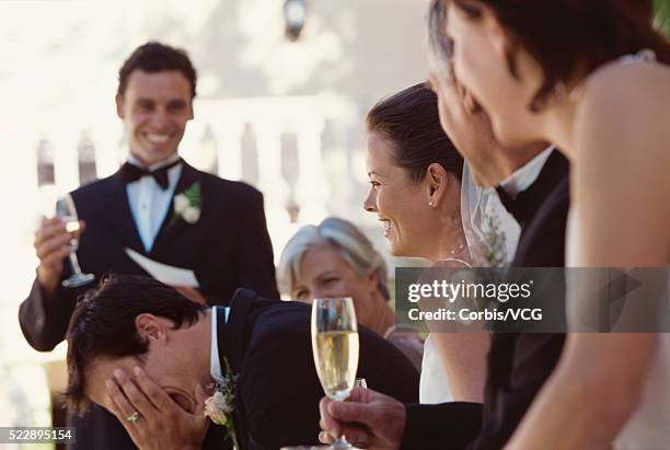 view of the best man embarrassing the groom during his speech at a wedding reception - best man stock pictures, royalty-free photos & images