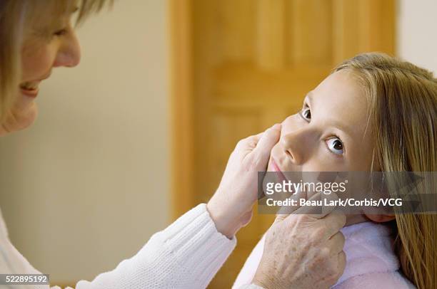 woman pinching cheeks of girl - aunt niece stock pictures, royalty-free photos & images