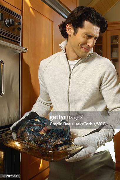 man holding burnt turkey - burnt cooking stock pictures, royalty-free photos & images