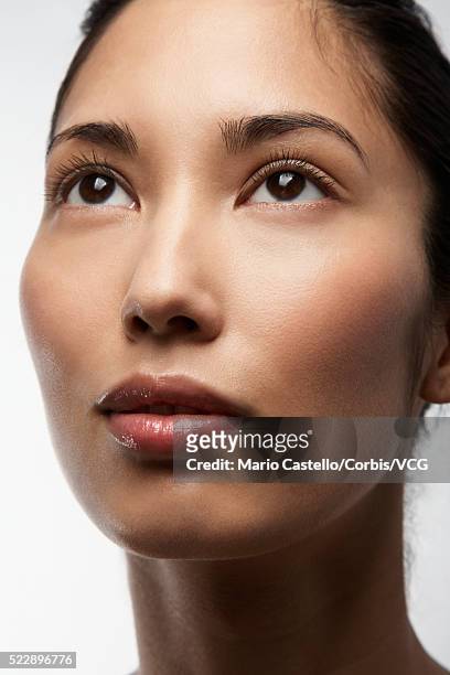 woman with brown eyes looking up - wishful skin imagens e fotografias de stock