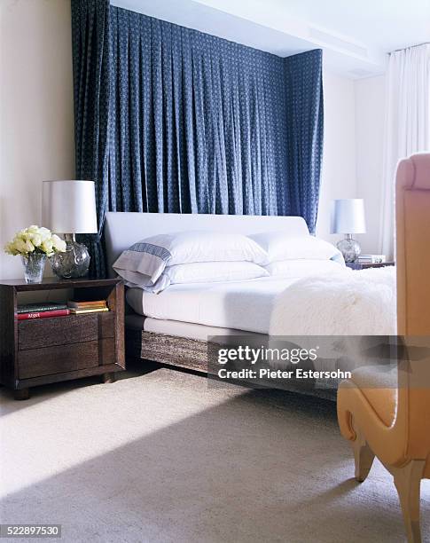 bed with curtains hanging behind headboard - headboard ストックフォトと画像