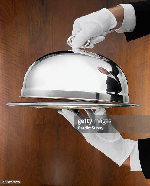 waiter carrying serving tray - domed tray photos et images de collection