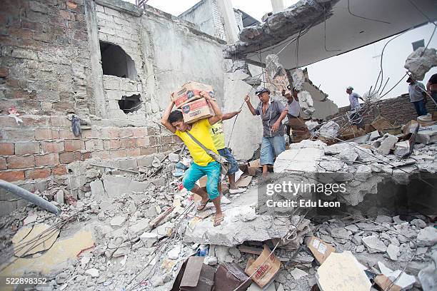 People loot what was left of a store after an earthquake struck Ecuador on April 21, 2016 in Pedernales, Ecuador. At least 400 people were killed...