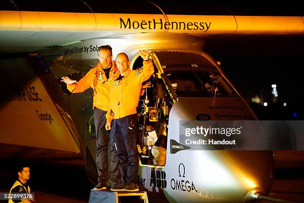 In this handout image supplied by Solar Impulse 2/GNR, pilots Andre Boschberg and Bertrand Piccard react to team members and media short before...
