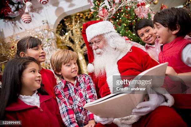 santa reading to the children - santa claus stock pictures, royalty-free photos & images