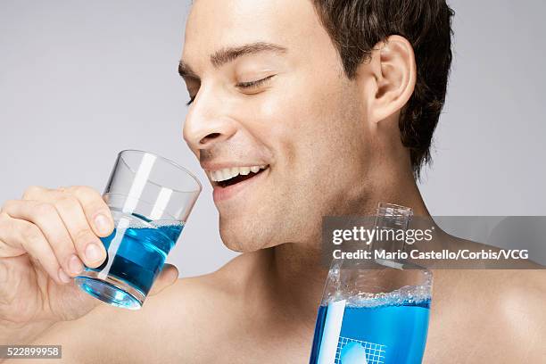 man using mouthwash - mouthwash stock-fotos und bilder