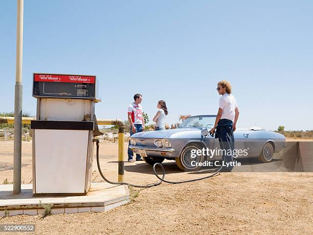 friends on road trip fueling car - old car garage stock pictures, royalty-free photos & images