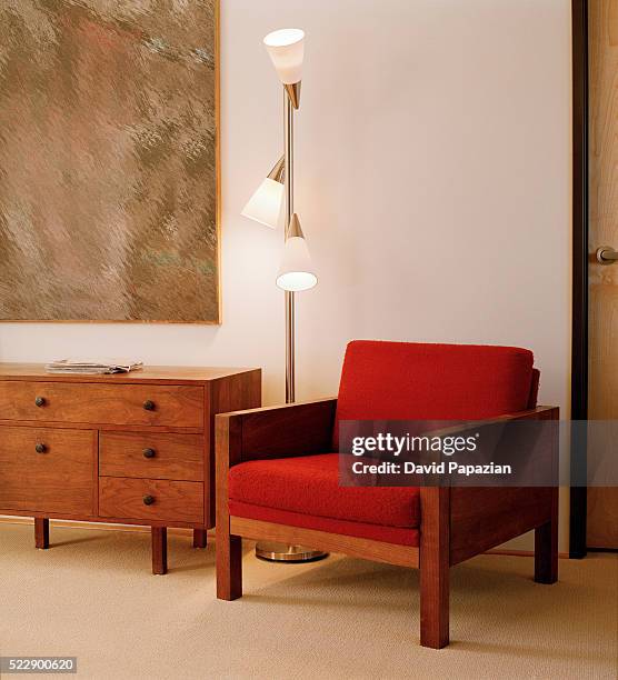 soothing light from a floor lamp illuminates a corner of the bedroom - commode stockfoto's en -beelden