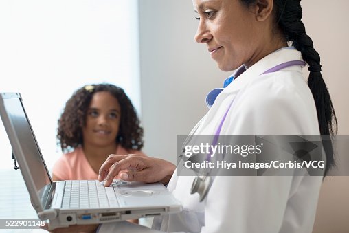 Pediatrician with patient (6-7) in examination room Pediatrician with patient (6-7) in examination room