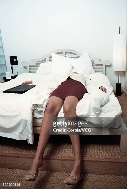 view of a businesswoman sprawled out on her bed after a workday - woman collapsing stock pictures, royalty-free photos & images