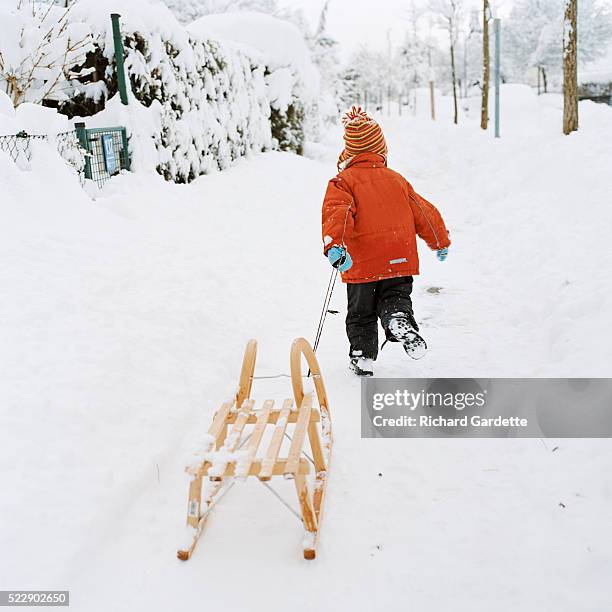 girl pulling toboggan - tobogganing 個照片及圖片檔