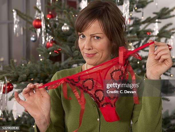 woman with panties at christmas tree - string stockfoto's en -beelden