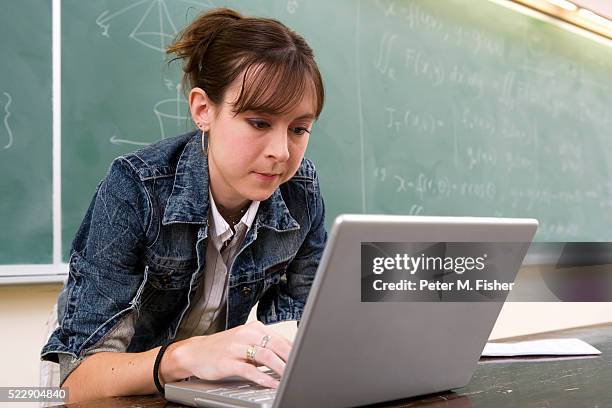 young woman in classroom using laptop - esperto foto e immagini stock