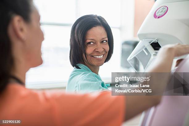 nurse preparing patient for mammography - mammogram diversity stock pictures, royalty-free photos & images