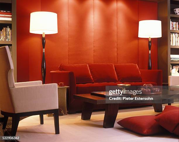 red velvet couch and padded wall in modern living room - roter samt stoff stock-fotos und bilder