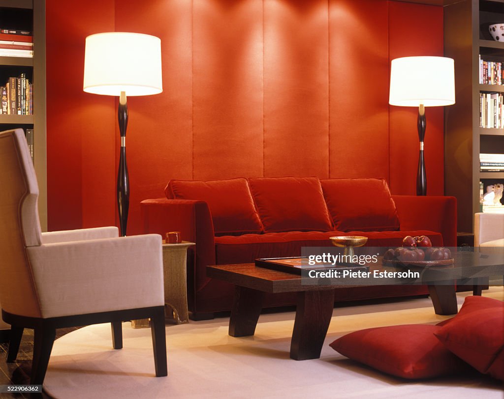 Red velvet couch and padded wall in modern living room
