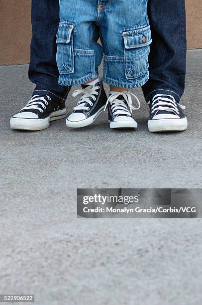 father walking with son - converse sports shoe foto e immagini stock