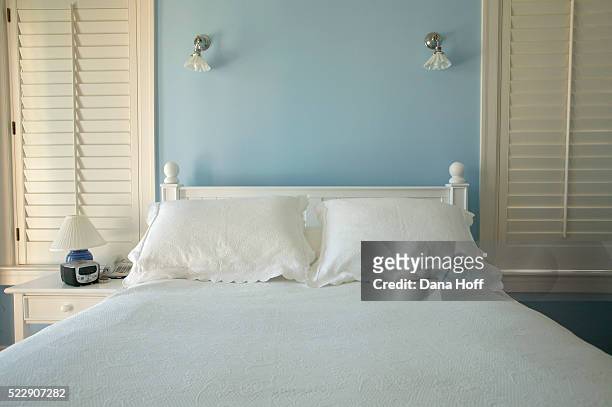fresh linens on the bed of in a robin's-egg blue bedroom - powder blue foto e immagini stock