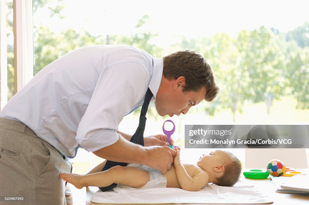 Father changing baby's diaper