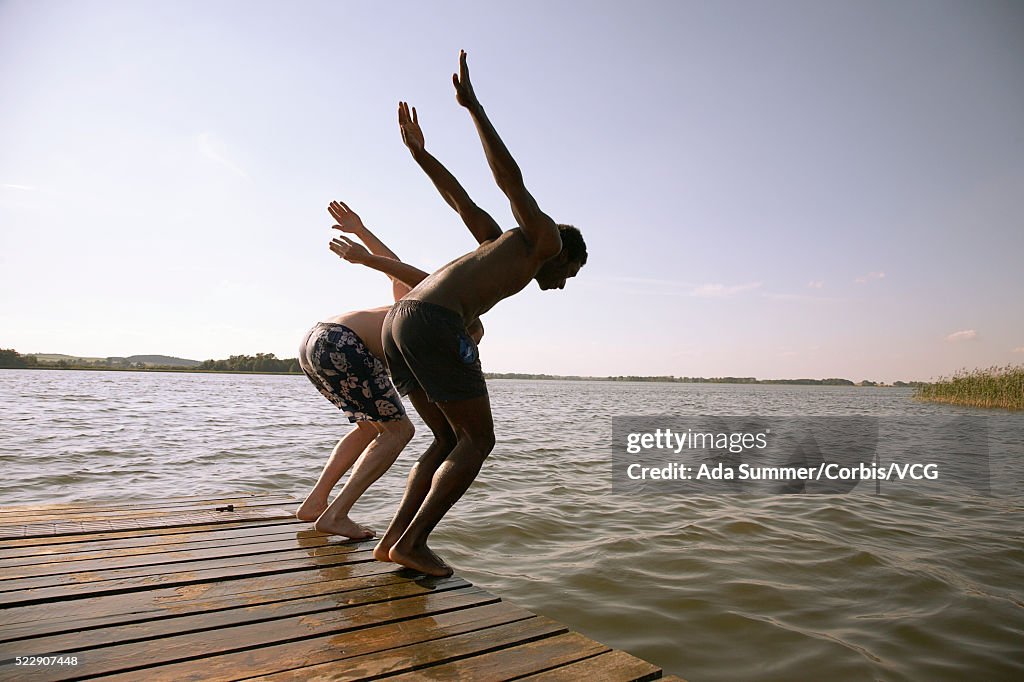 Two men jumping off dock