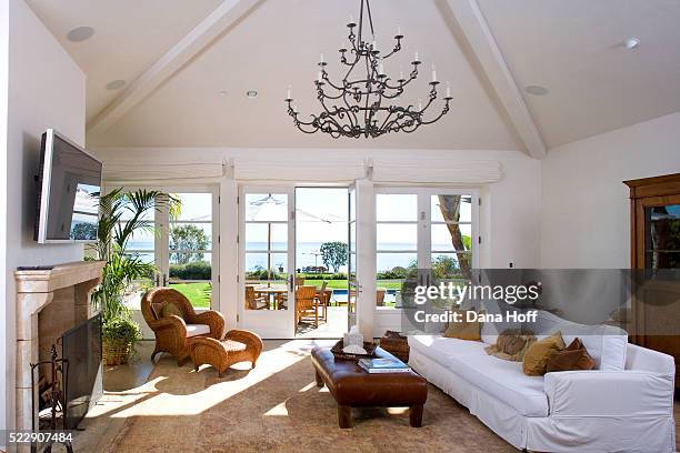 an elegant chandelier is suspended from a ceiling in a living room - ceiling stock pictures, royalty-free photos & images