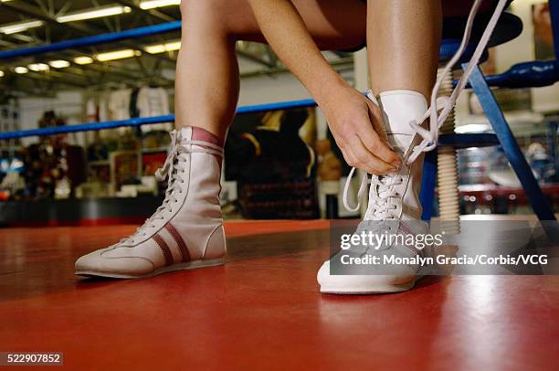 boxer tying up boots in boxing ring - boot spur stock pictures, royalty-free photos & images