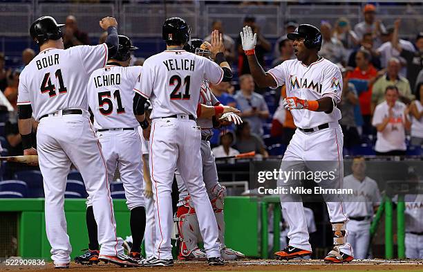 Marcell Ozuna of the Miami Marlins is congratulated after hitting a three run home run in the first inning during a game against the Washington...