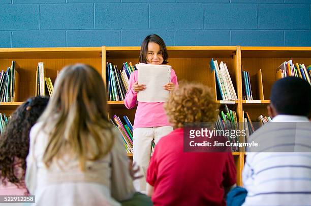little girl giving presentation in school library - kid presenting stock pictures, royalty-free photos & images